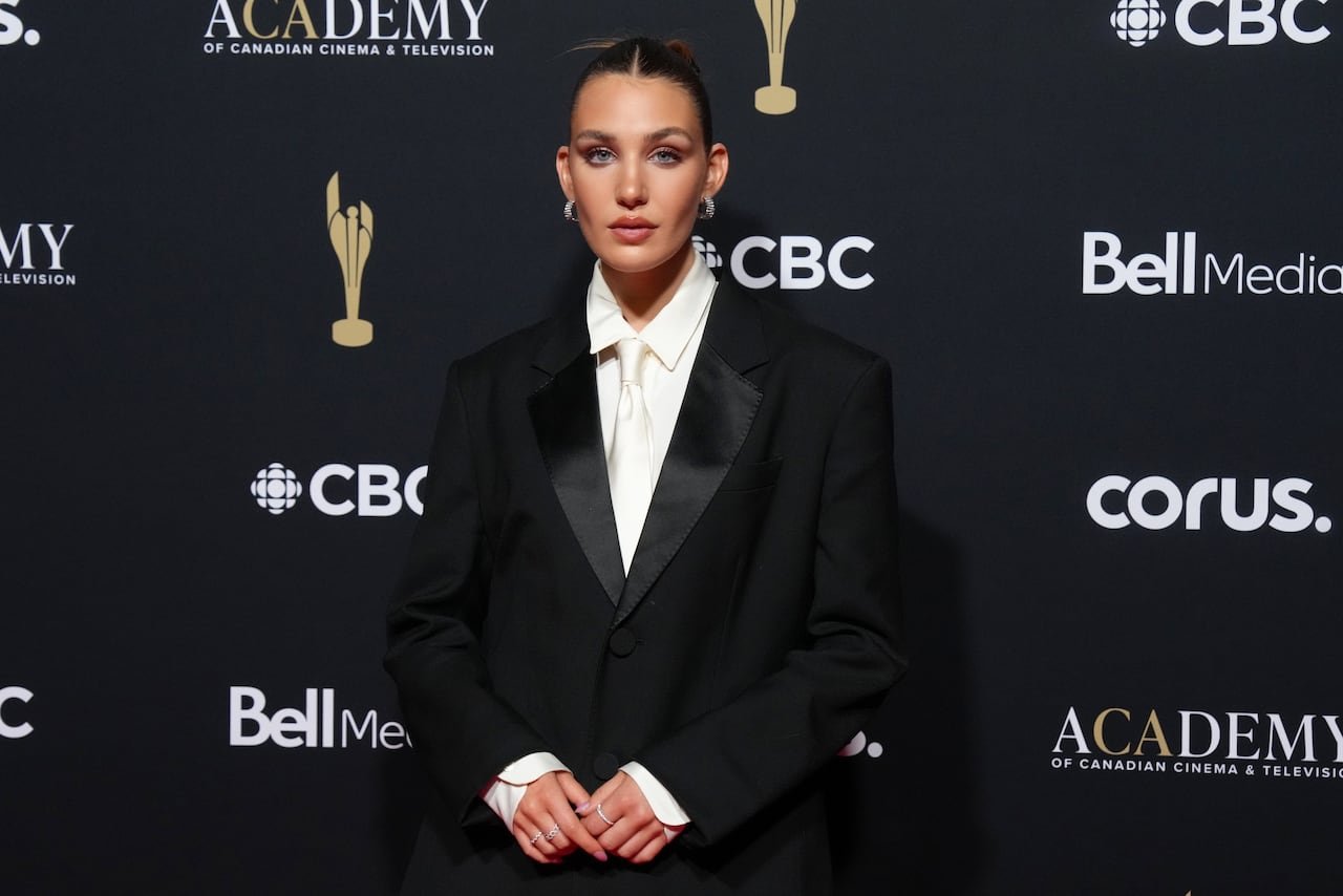 Sophie Nélisse dressed sharply sporting black tailored tuxedo combined elegantly wit hwhite satin tie.